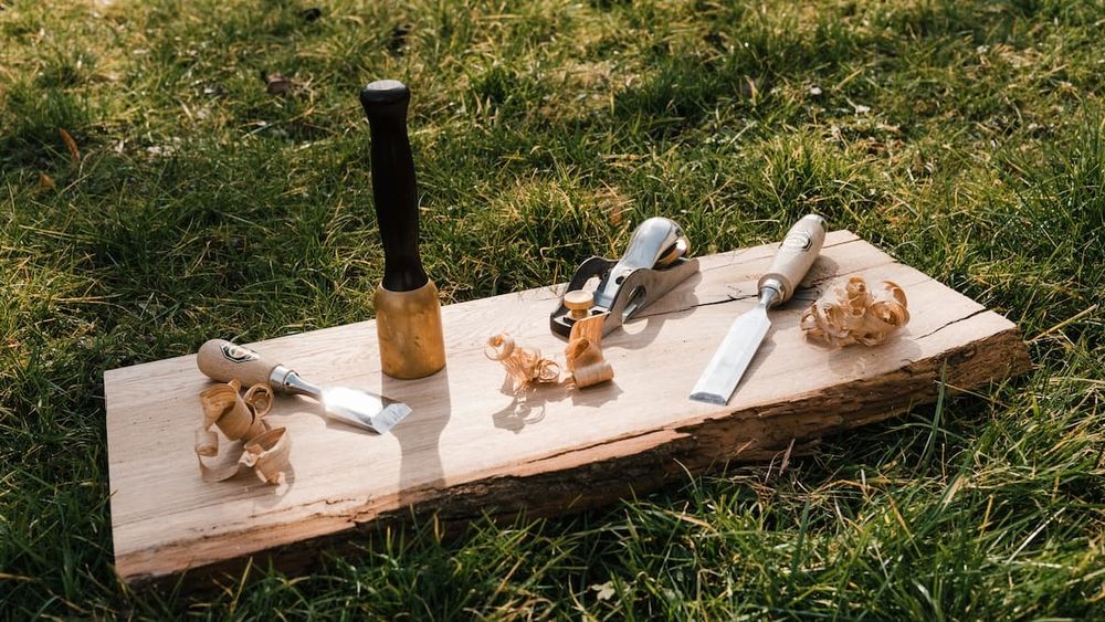 Tischlerwerkzeug auf einem Holzbrett mit Sägespänen