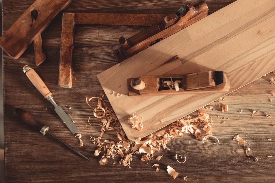 Tischlerwerkzeug auf einem Holzbrett mit Sägespänen